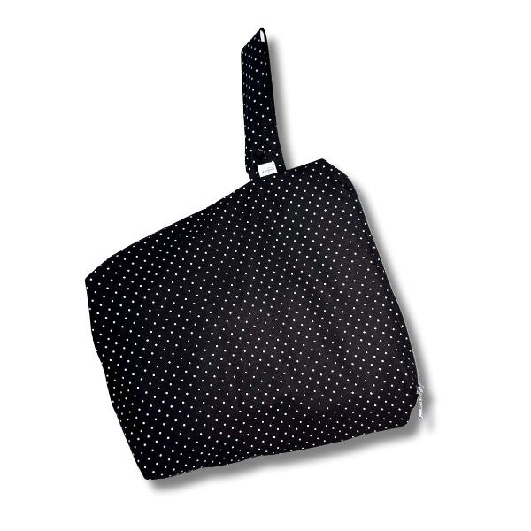 Black bag with white polka dots on a white background