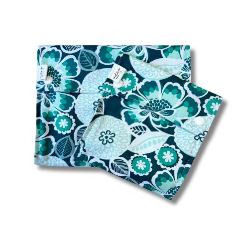Two teal reusable bags with a floral pattern on a white background