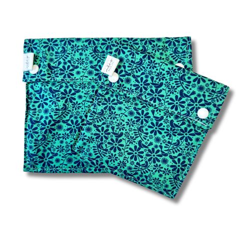 Two teal reusable bags with a floral pattern on a white background