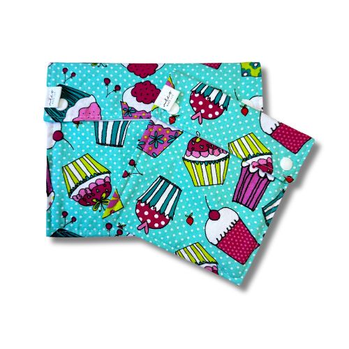 Two teal reusable bags with a cupcake pattern on a white background