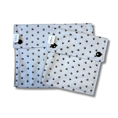 Two teal reusable bags with a paw print pattern on a white background