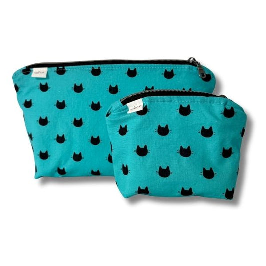 Two turquoise pouches with black cat patterns on a white background