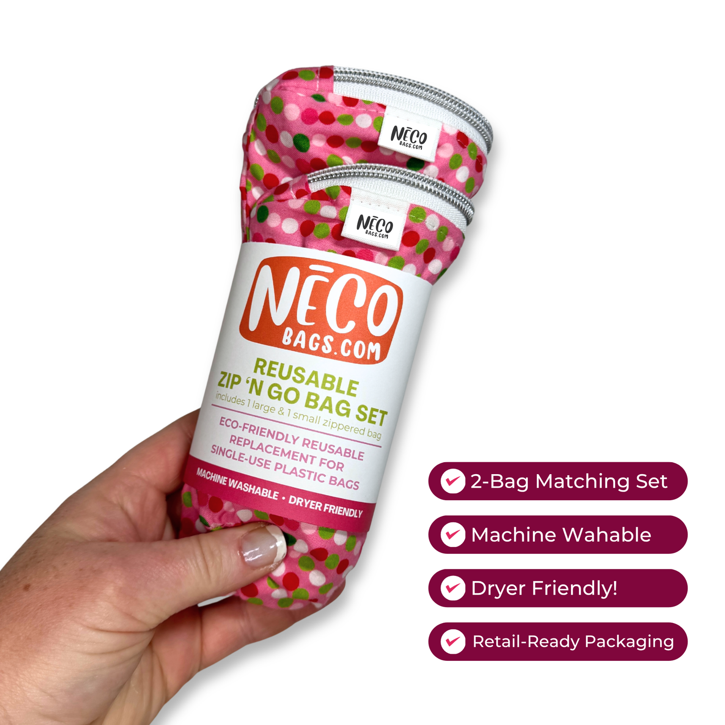 A hand holds a pink reusable zip-in go bag set with a colorful polka-dot pattern and a white label. The label reads 'NÉCO BAGS.