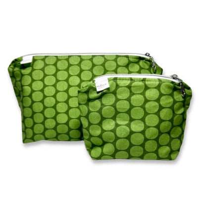 Two green polka dot bags with zippers on a white background
