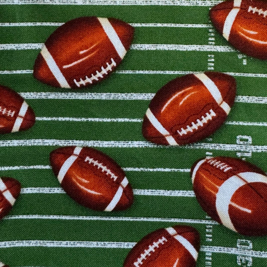 Pattern of footballs on a green field background