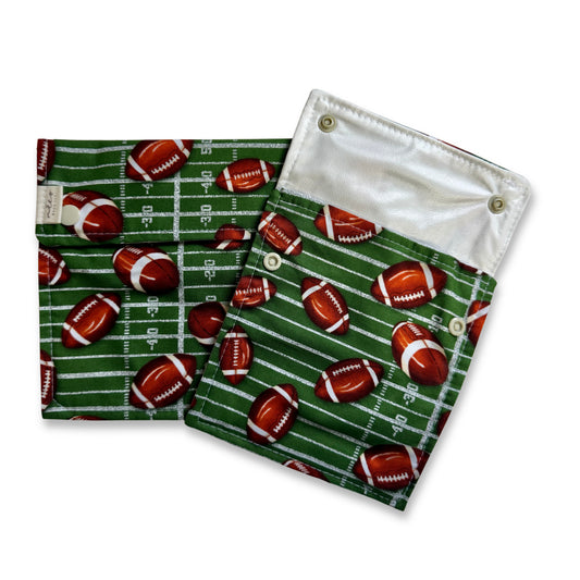 Two snack and sandwich bags  shown on a white background. The pouches have a green background with a footballs and football field markings. Cute fun, and colorful machine washable food bags