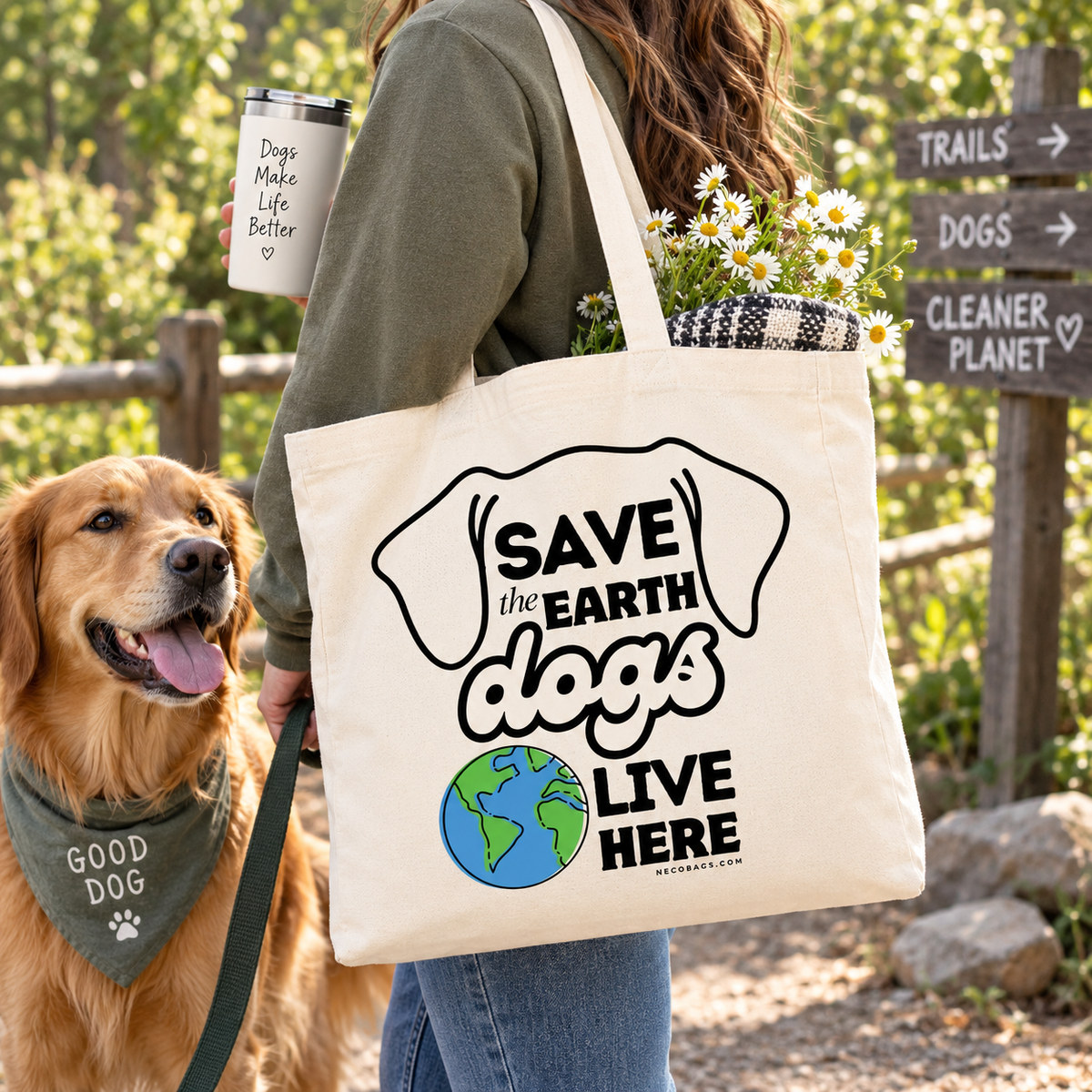 Alt text:
Woman carrying a reusable canvas tote with “Save the Earth, Dogs Live Here” graphic while walking outdoors with a golden retriever.