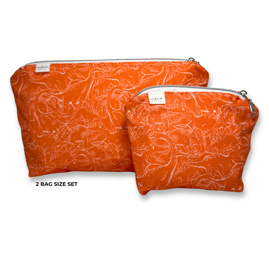 Two orange zippered pouches with a white dinosaur line drawings, shown on a white background with the text '2 BAG SIZE SET' below the larger bag. Machine Washable Cosmetic Bags 