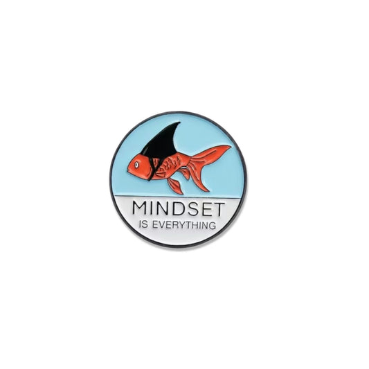 A circular enamel pin featuring a red and black fish on a light blue background, with the text 'MINDSET IS EVERYTHING' below it, shown on a plain white background.