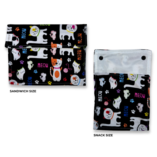 Two snack and sandwich bags  shown on a white background, labeled Sandwich Size and Snack Size. The pouches have a black background with a colorful cartoon cat print, paw prints, and the word 'MEOW' in pink, blue, and orange. Cute fun, and colorful machine washable food bags