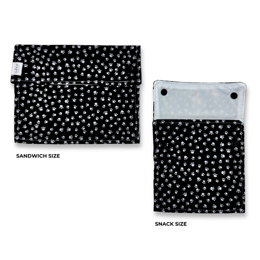 two reusable machine washable snack and sandwich bags. Black background with small white paw prints. 