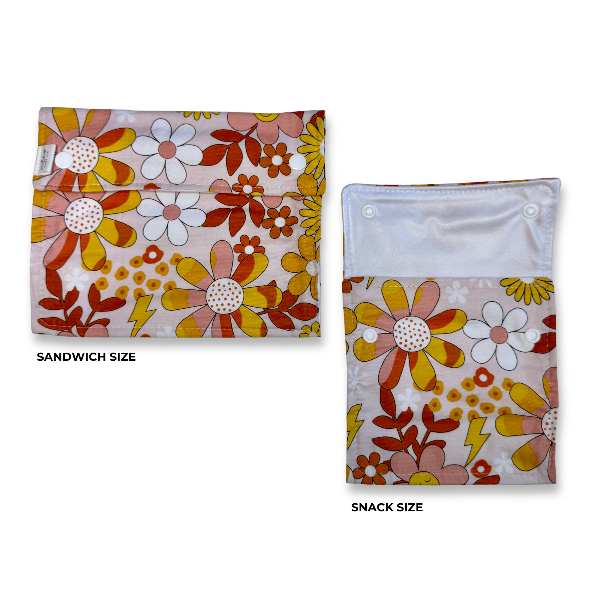 Two snack and sandwich bags  shown on a white background, labeled Sandwich Size and Snack Size. Two reusable food safe bags with a retro floral print are shown on a white background, labeled SANDWICH SIZE and SNACK SIZE. The bags have a light pink base with large daisy-like flowers in yellow, orange, white, and pink, plus red and orange leaves and small yellow lightning-bolt motifs.