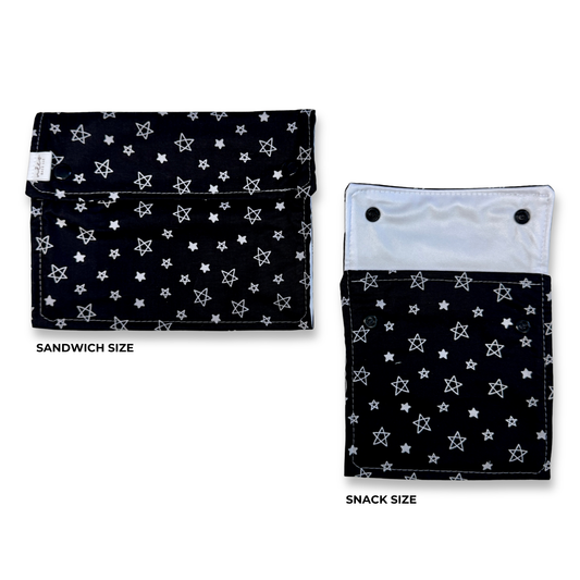 Two fabric snack pouches shown on a white background, labeled SANDWICH SIZE and SNACK SIZE. Both pouches have a black base with a white star pattern and white stitching. Machine Washable snack and sandwich bags