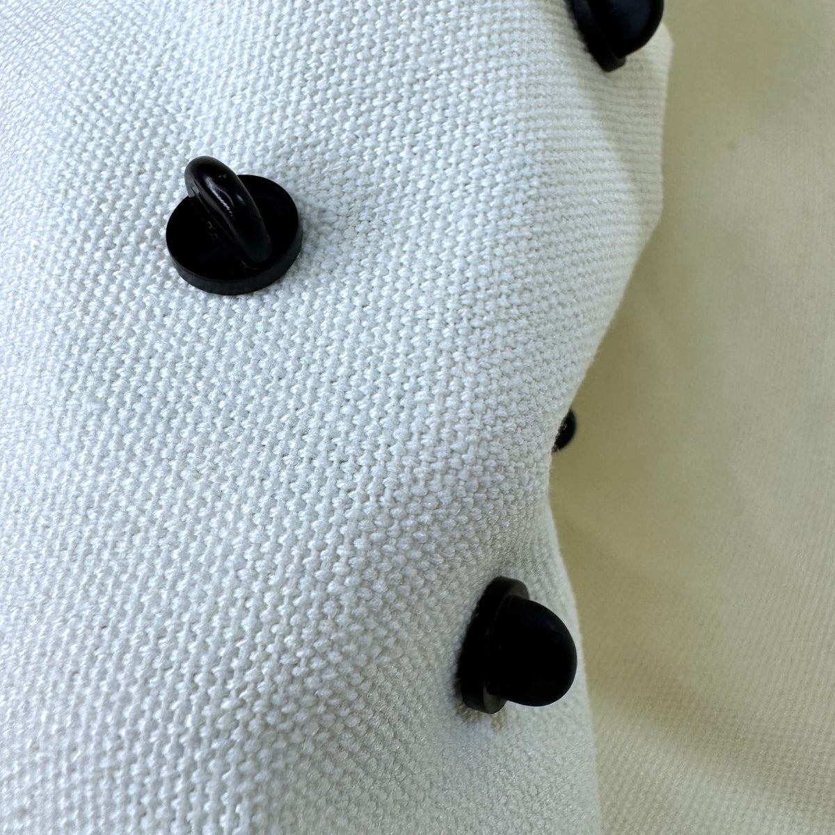 canvas tote showing the back side of the pin on the bag with the rubber backings