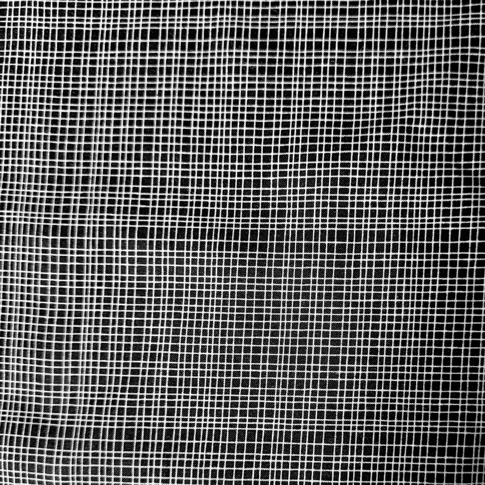 A close-up of a black mesh fabric with a white grid pattern, filling the entire frame.
