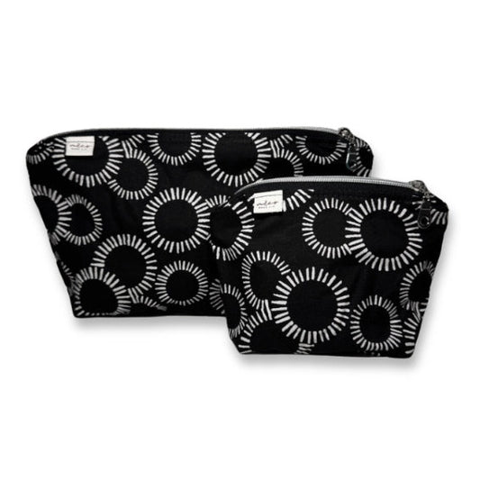 Two black makeup bags with white circular pattern on a white background