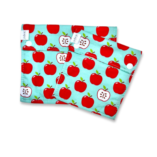 Two reusable snack bags with red apple pattern on a light blue background
