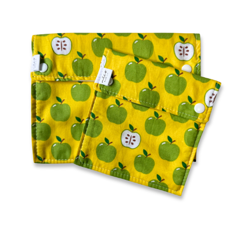 Yellow reusable snack bags with green apple pattern on a white background