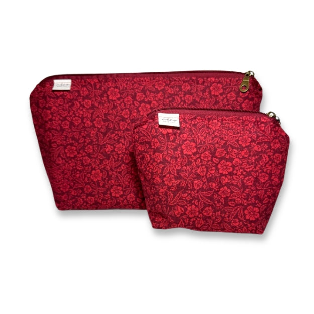 Two red floral-patterned pouches on a white background